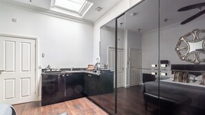 A modern kitchen with dark cabinetry, a built-in island, and a large mirror.