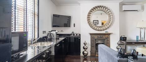 A modern kitchen with a large island, built-in appliances, and a flat-screen TV.