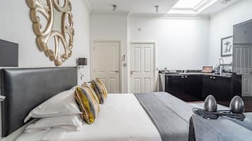 Una habitación de hotel con una cama grande, un escritorio, un armario y un baño.