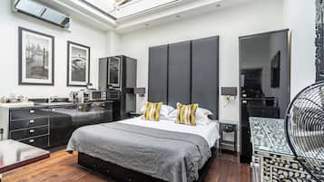 A modern bedroom with a large bed, bedside tables, a built-in wardrobe, and a skylight.