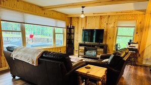 A cozy living room with a leather sofa, a wooden coffee table, and a fireplace.