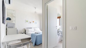 A modern hotel room with a bed, a desk, and a chair. There is a door leading to the bathroom. - Pinzochere 16 - Studio Apartment, Sleeps 2 (Firenze)
