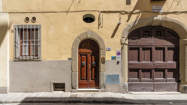 A building with a wooden door and an arched entrance, a barred window, and a sign indicating a no parking zone. - Pinzochere 16 - Studio Apartment, Sleeps 2 (Firenze)