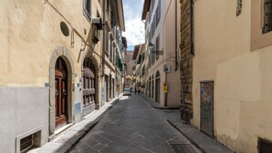 A narrow street with stone pavement, historic buildings with arched doorways, and a clear sky. - Pinzochere 16 - Studio Apartment, Sleeps 2 (Firenze)
