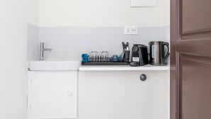 A compact kitchenette with a sink, a coffee maker, and a kettle on the countertop. - Pinzochere 16 - Studio Apartment, Sleeps 2 (Firenze)