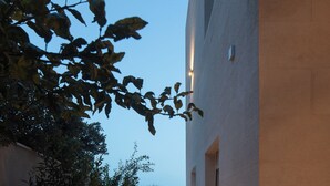 Ein modernes Gebäude mit Glasfassade, einer Holztreppe und Blick auf das Meer.