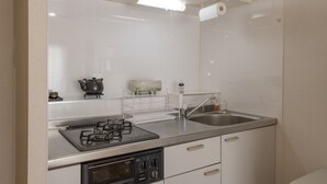 Una cocina moderna con estufa a gas, un lavamanos y horno empotrado.