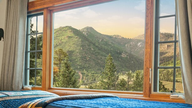 A room with a large window offering a view of a mountainous landscape. - Private Family Home: Spacious Patio, Hot Tub, Fire Pit by Forest & Peak Retreats (Cascade-Chipita Park)