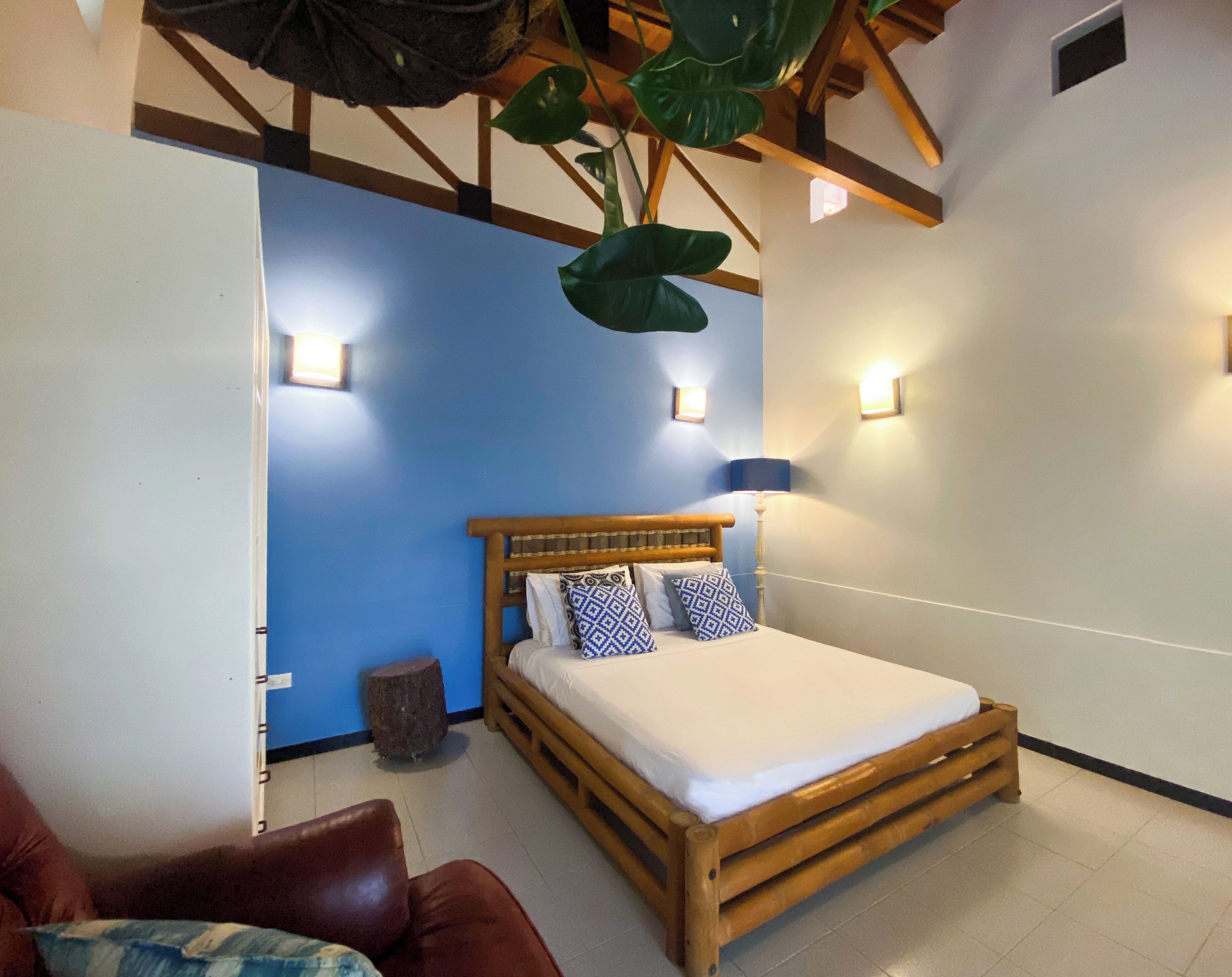 A bedroom with a wooden bed, blue walls, and two bedside lamps.