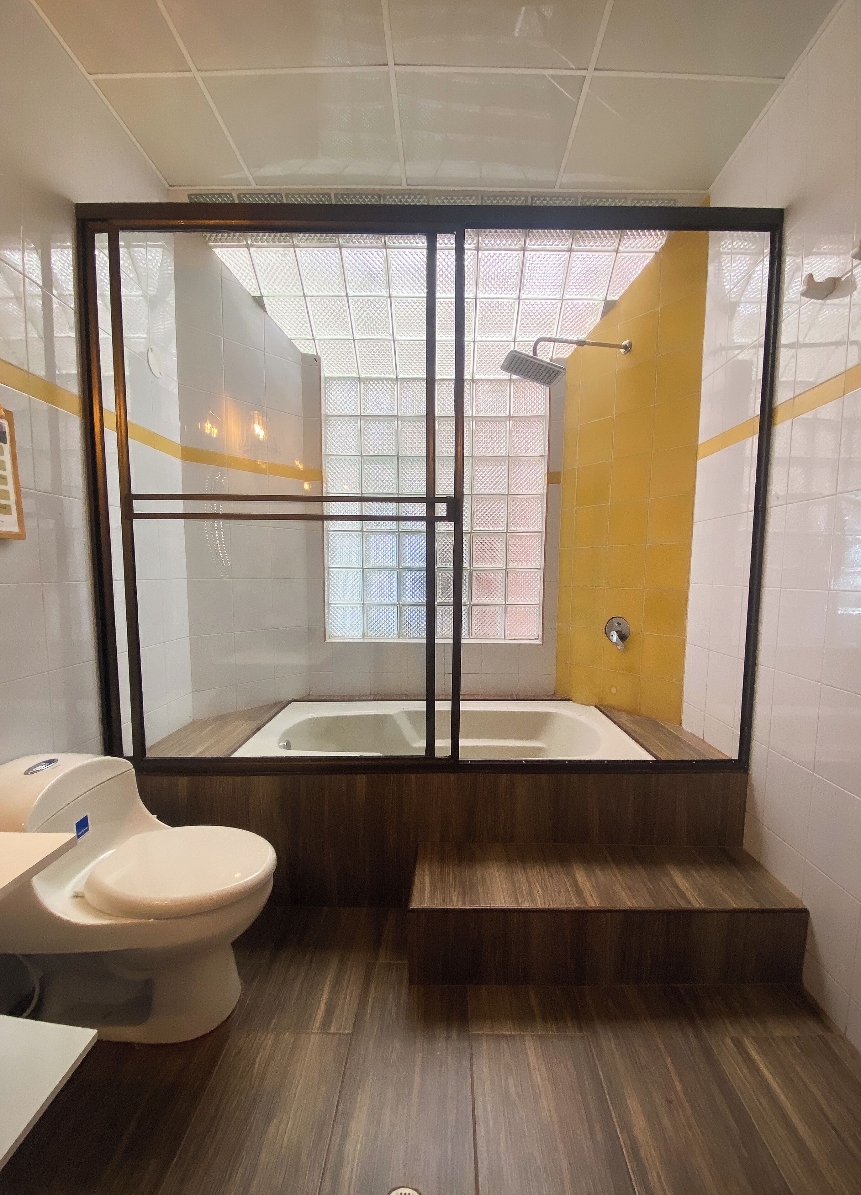 Une salle de bain moderne dotée d’une douche à parois de verre, d’une baignoire et de toilettes.