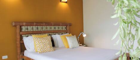 A bed with a wooden headboard, two wall-mounted lights, and a bedside lamp.