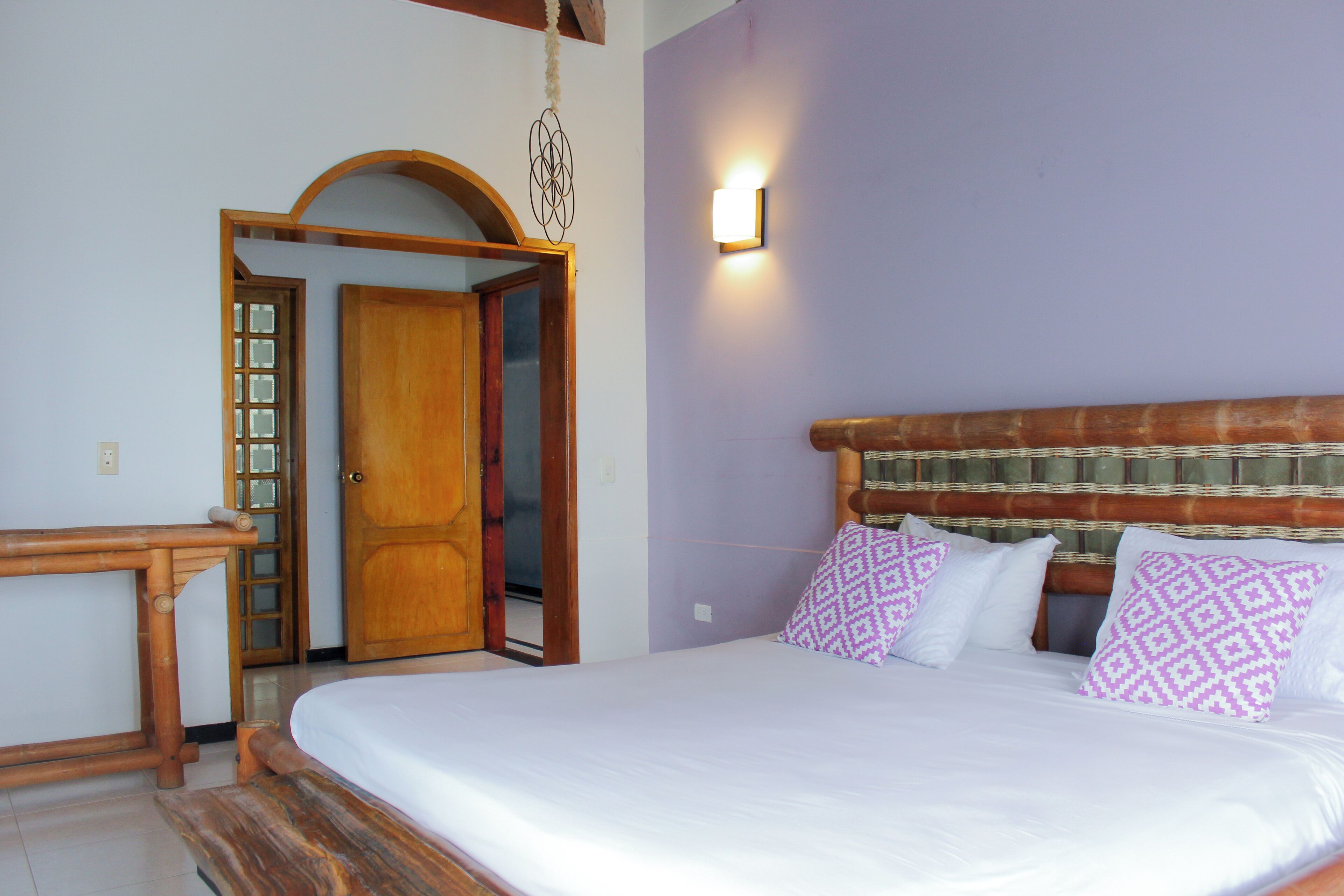 A bedroom with a bed, wooden headboard, and a nightstand.