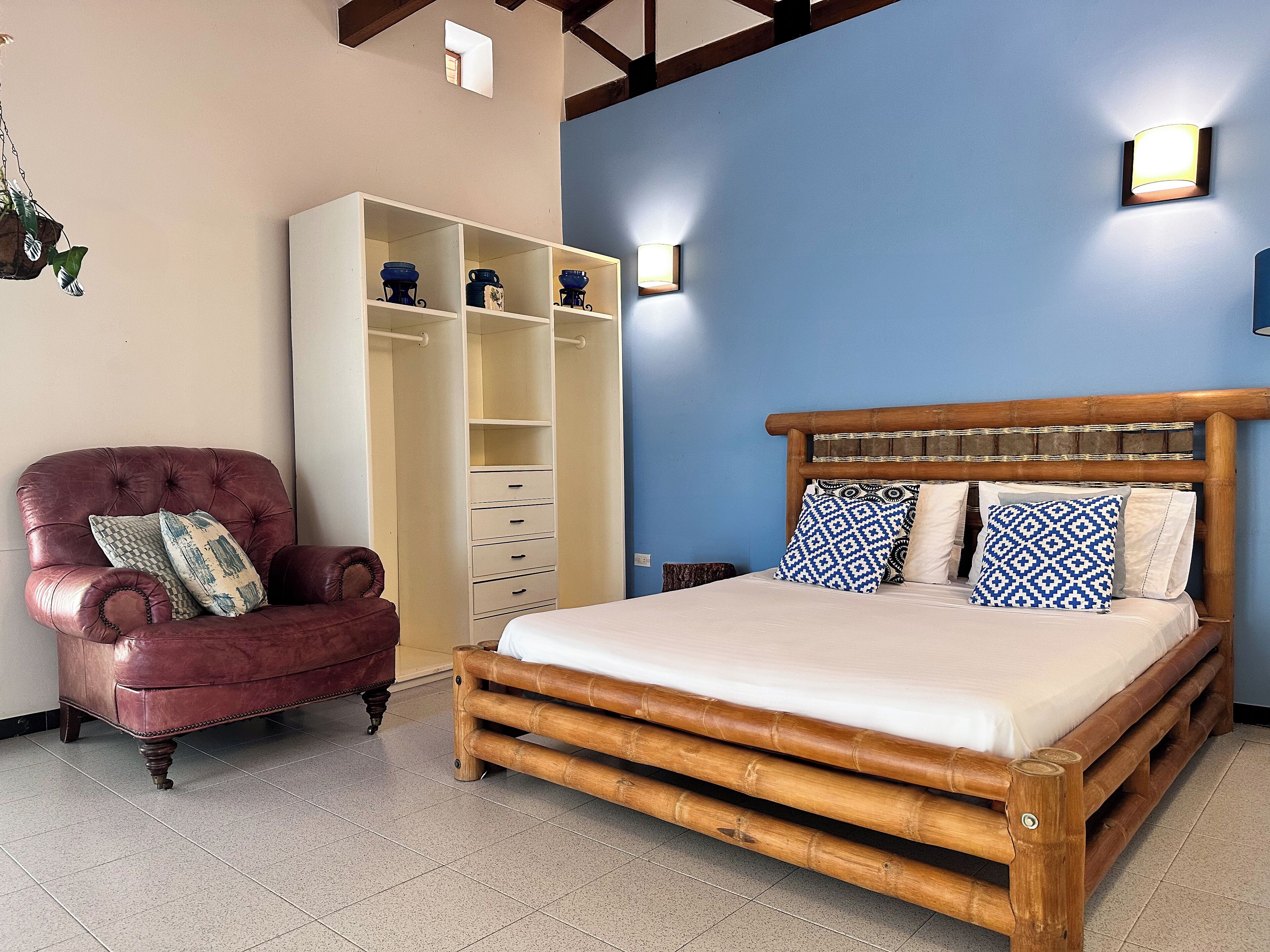 A bedroom with a bed, a wardrobe, and a chair.