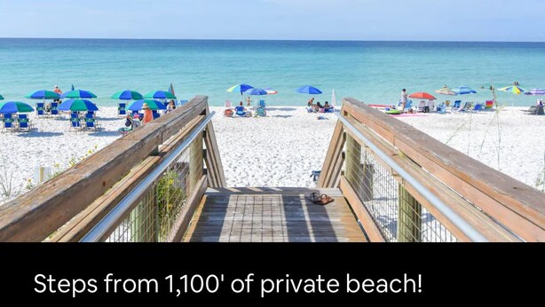 Une plage avec une promenade en bois menant au rivage, bordée de parasols et de chaises de plage.