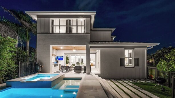 A modern two-story house with a swimming pool, outdoor seating, and a well-lit interior. - Brand new 4bdr, 5 bath luxury house 1 mile from 5th Avenue and Beached (Naples)