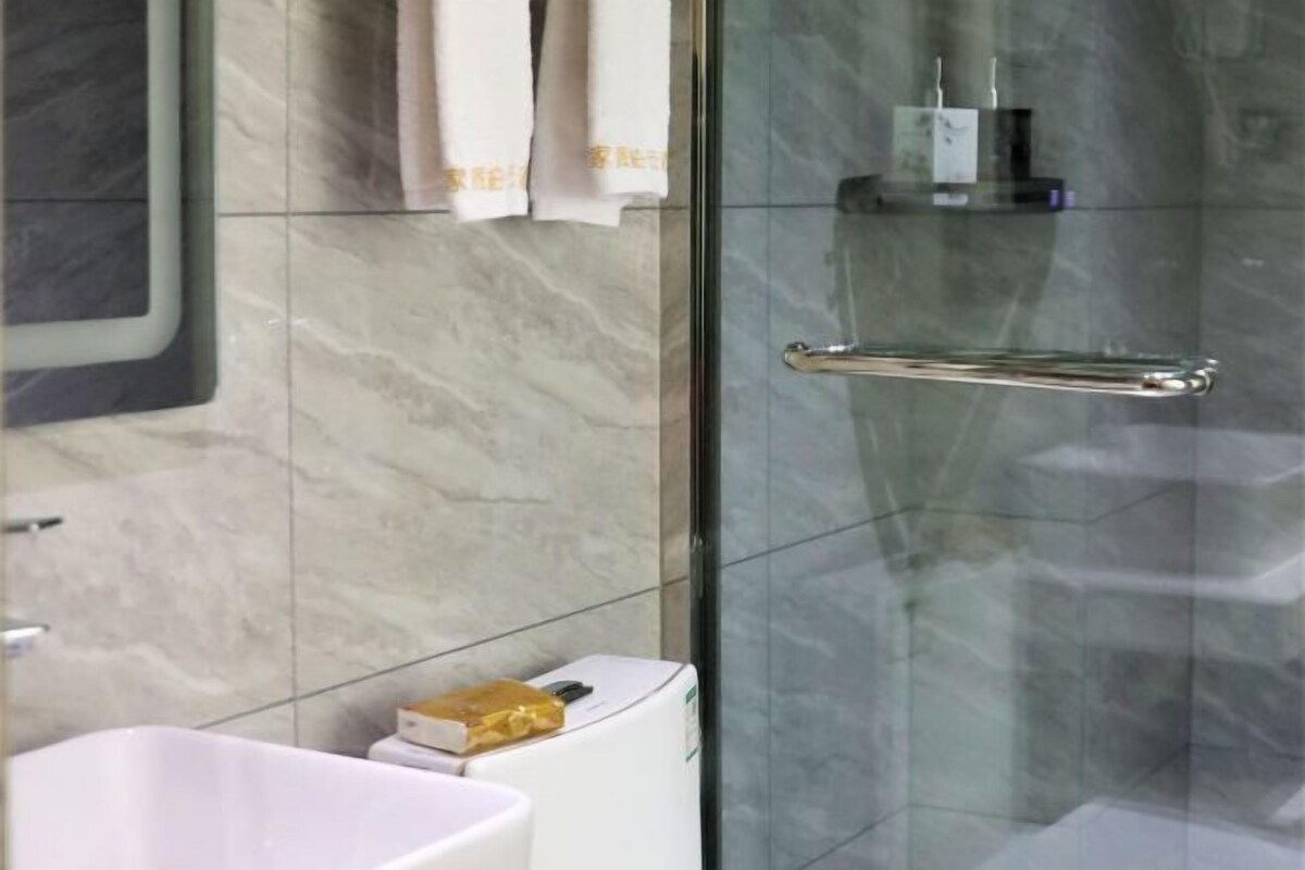A bathroom with a white sink, a glass shower enclosure, and a towel rack.
