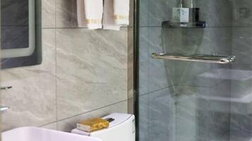 A bathroom with a white sink, a glass shower enclosure, and a towel rack.