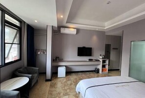 A hotel room with a bed, a desk, a chair, a TV, and a window. - Nandan Home Inn Paibaiyun Hotel (Nandan)