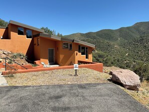 A modern guest house with a patio, a guest parking sign, and a mountainous backdrop. - Bisbee Luxe "Eco-Casita" Cool Mountain Retreat with SRT* (Cochise County)
