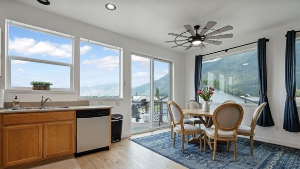 Una cocina moderna con armarios de madera, lavavajillas y un ventanal con vistas a una pintoresca vista de la montaña.