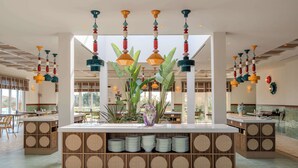A modern interior with a central island, hanging pendant lights, and a view of the outdoors. - Terradamari Resort & Spa Marina di Modica, Tapestry by Hilton (Modica)