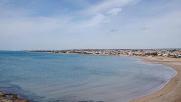 A coastal town with a beach and clear blue sea.