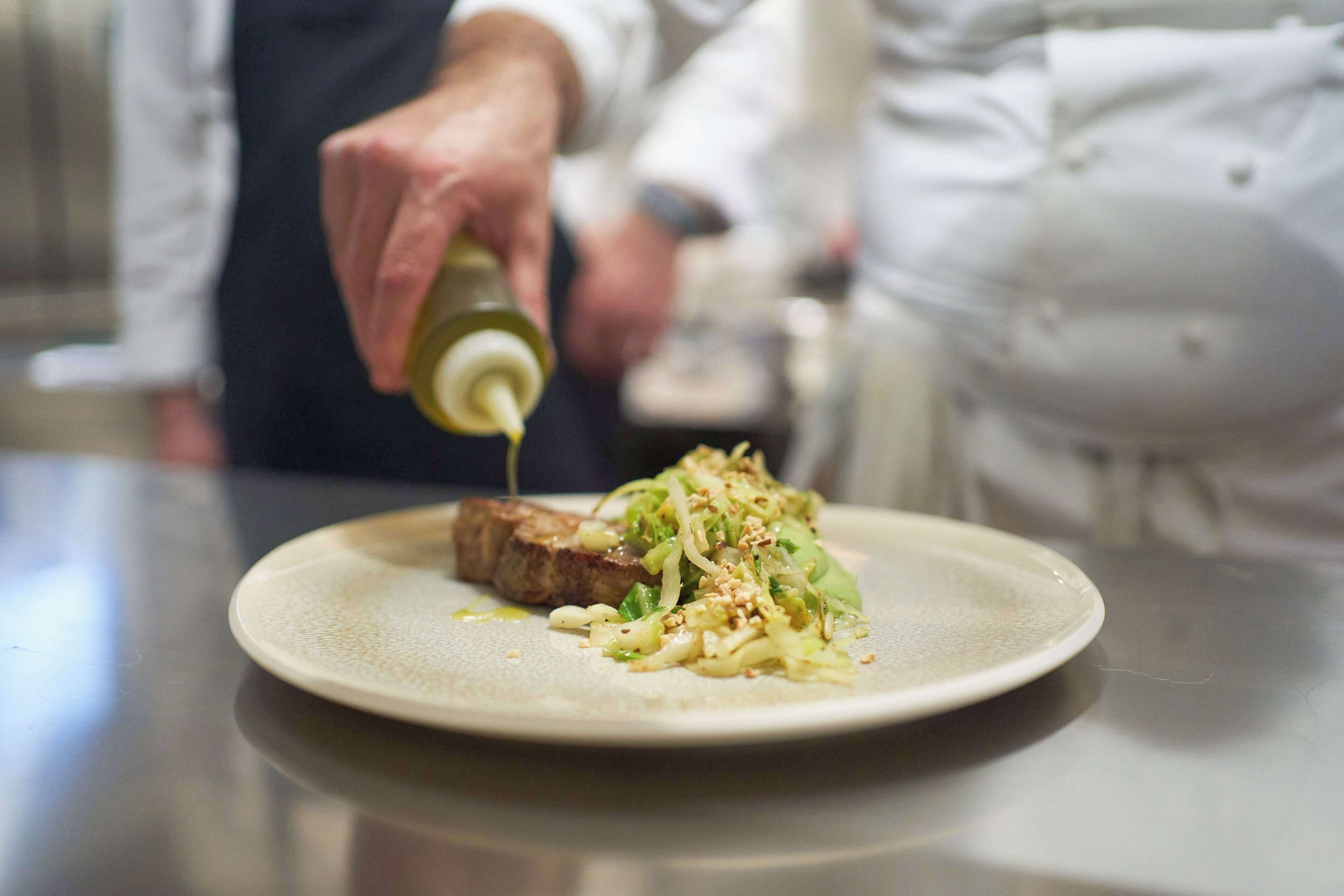 Un cocinero preparando un plato.