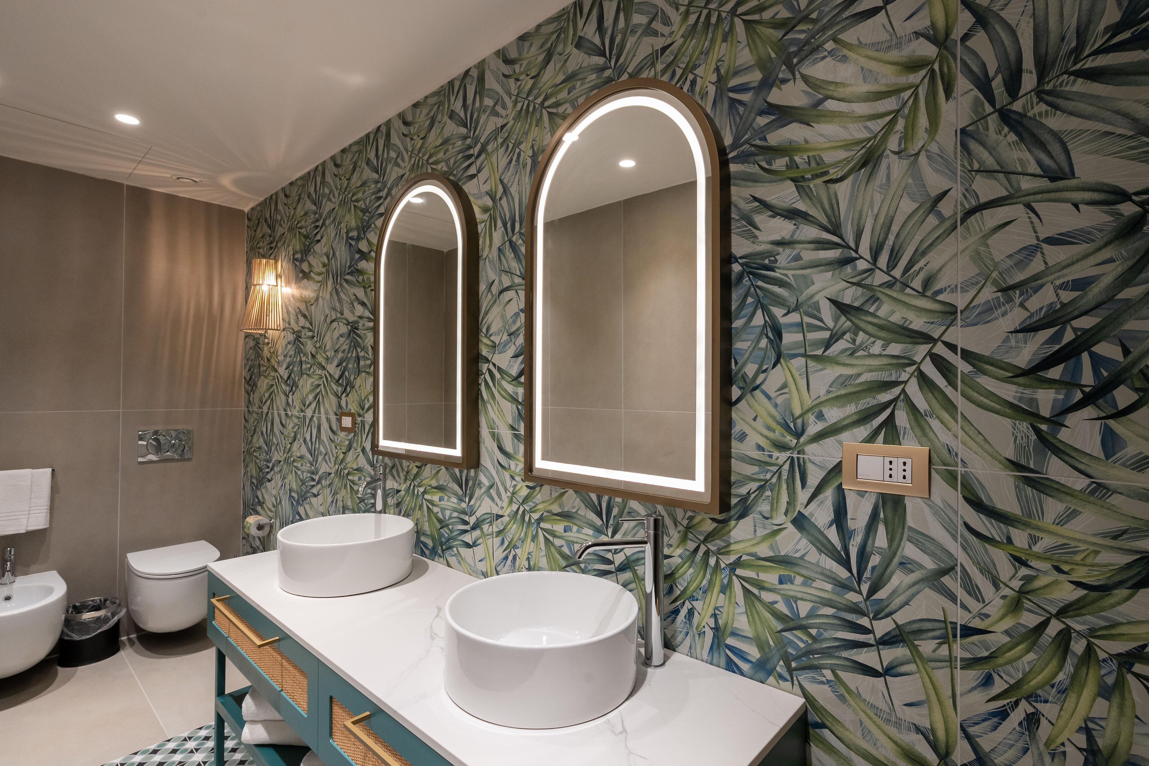 Une salle de bain avec deux lavabos, un miroir et un porte-serviettes.