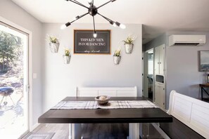 A modern kitchen with a dining table, pendant lights, and potted plants. - Family Cabin w/games & fire-pit (Payson)