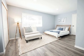A bedroom with a bed, a chair, a lamp, and a window. - Family Cabin Games & Fire Pit (Payson)