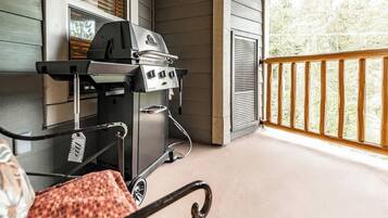 A covered outdoor area with a grill and a wheelchair.