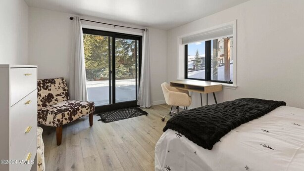 A modern bedroom with a bed, a desk, a chair, and a wardrobe. - 10min Beaver Creek | 15 min Vail (Avon)