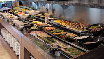 Een buffet met verschillende soorten eten en bestek.