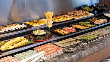 A buffet with various food items including cheeses, salads, and dips.
