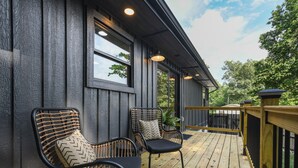 A wooden deck with two wicker chairs and a potted plant. - Smokies Pond Escape/Secluded Mtn cabin w/pond/Fish’n/Hot tub/2 fenced yards/Pets (Pigeon Forge)
