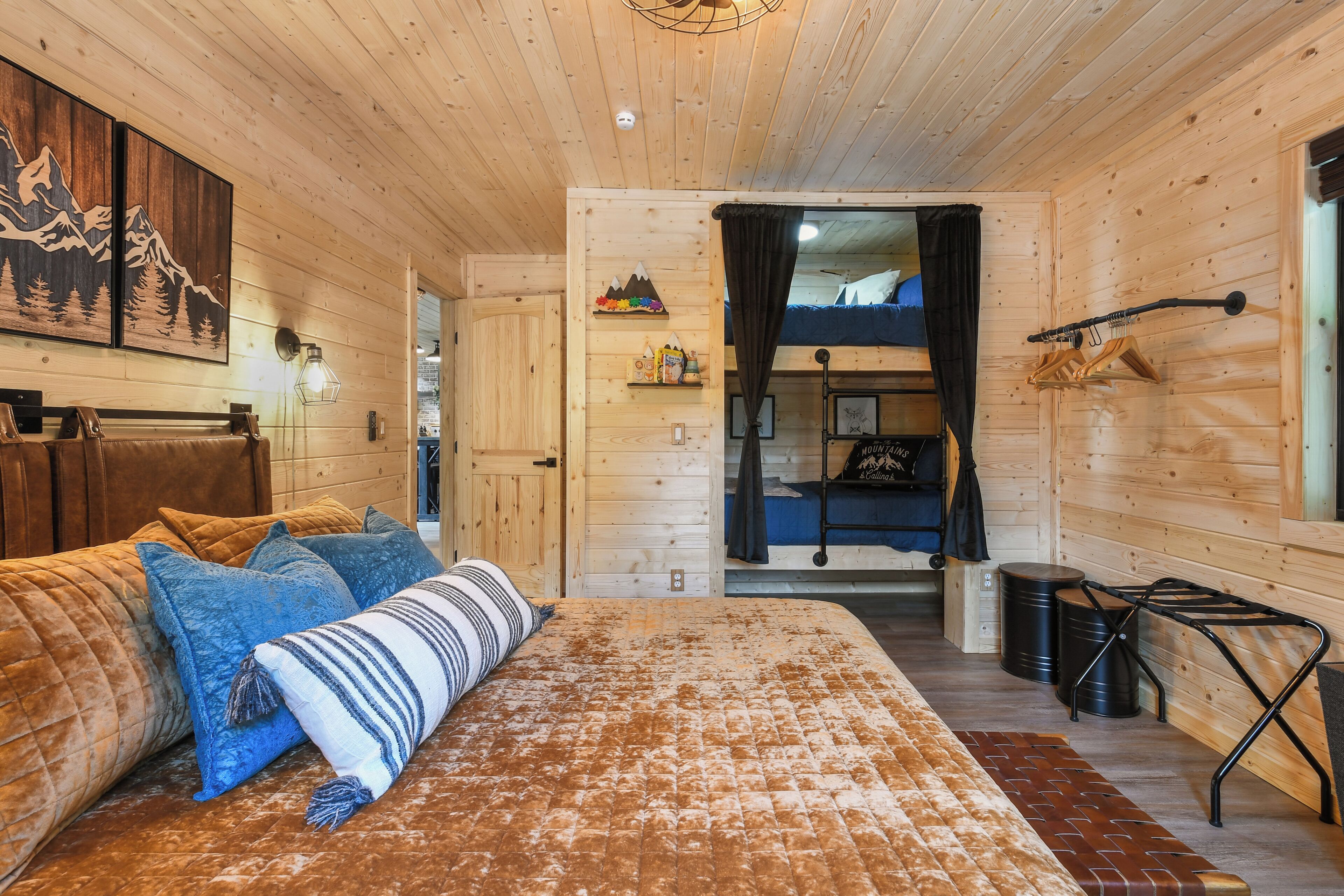 A cozy wooden room with a bed, a bench, and a small table.