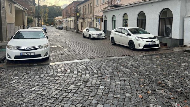 A cobblestone street lined with buildings, some with balconies and air conditioning units. - Hotel WB (Kutaisi)