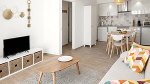En moderne lejlighed med stue, spiseområde og køkken.