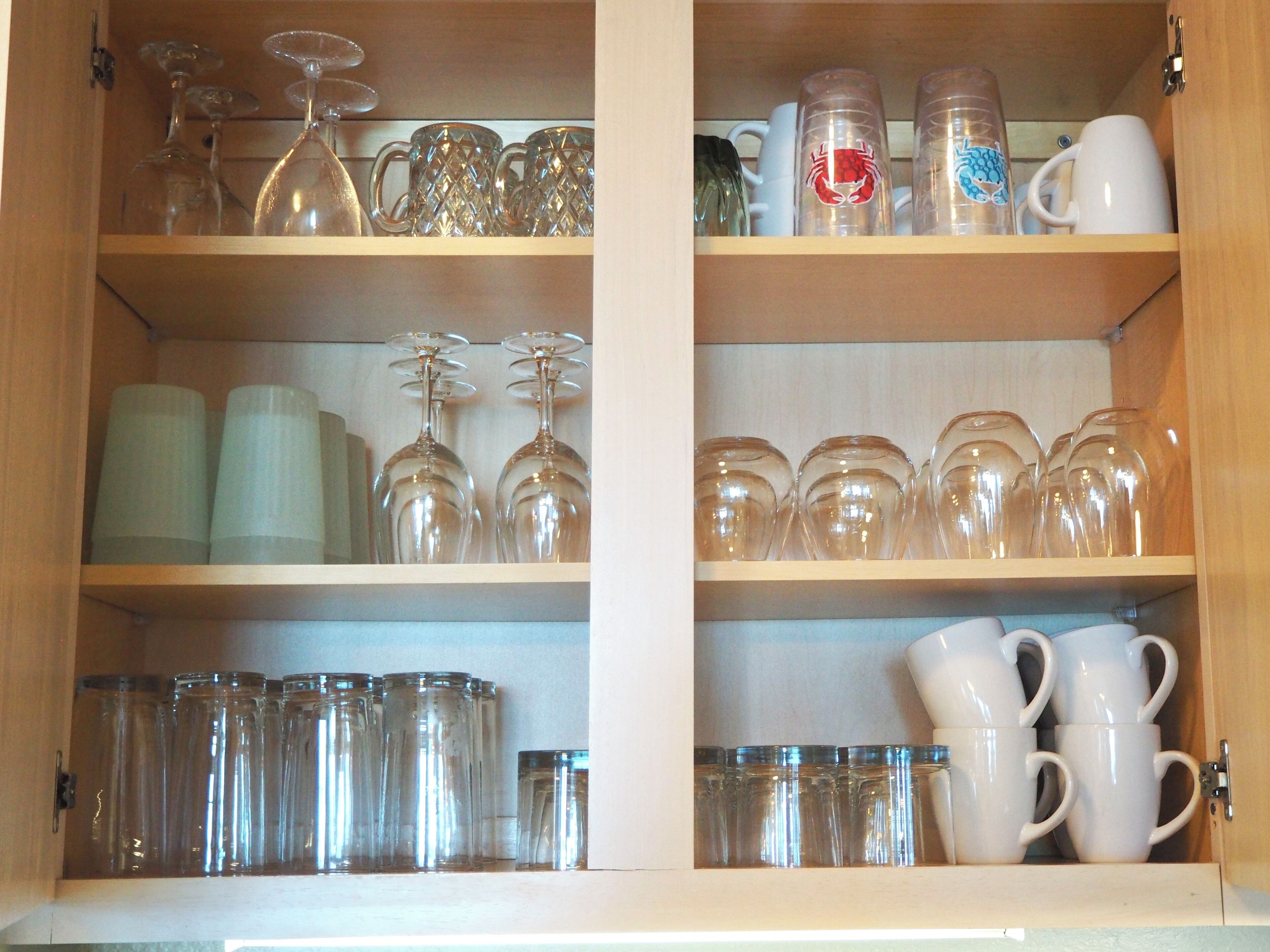 Un mueble con estantes que contiene diferentes vasos y tazas.