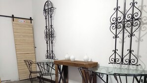 A room with a wooden table, four metal chairs, and decorative metal wall art. - Loft MN960 Mty centro cerca de todo (Monterrey)