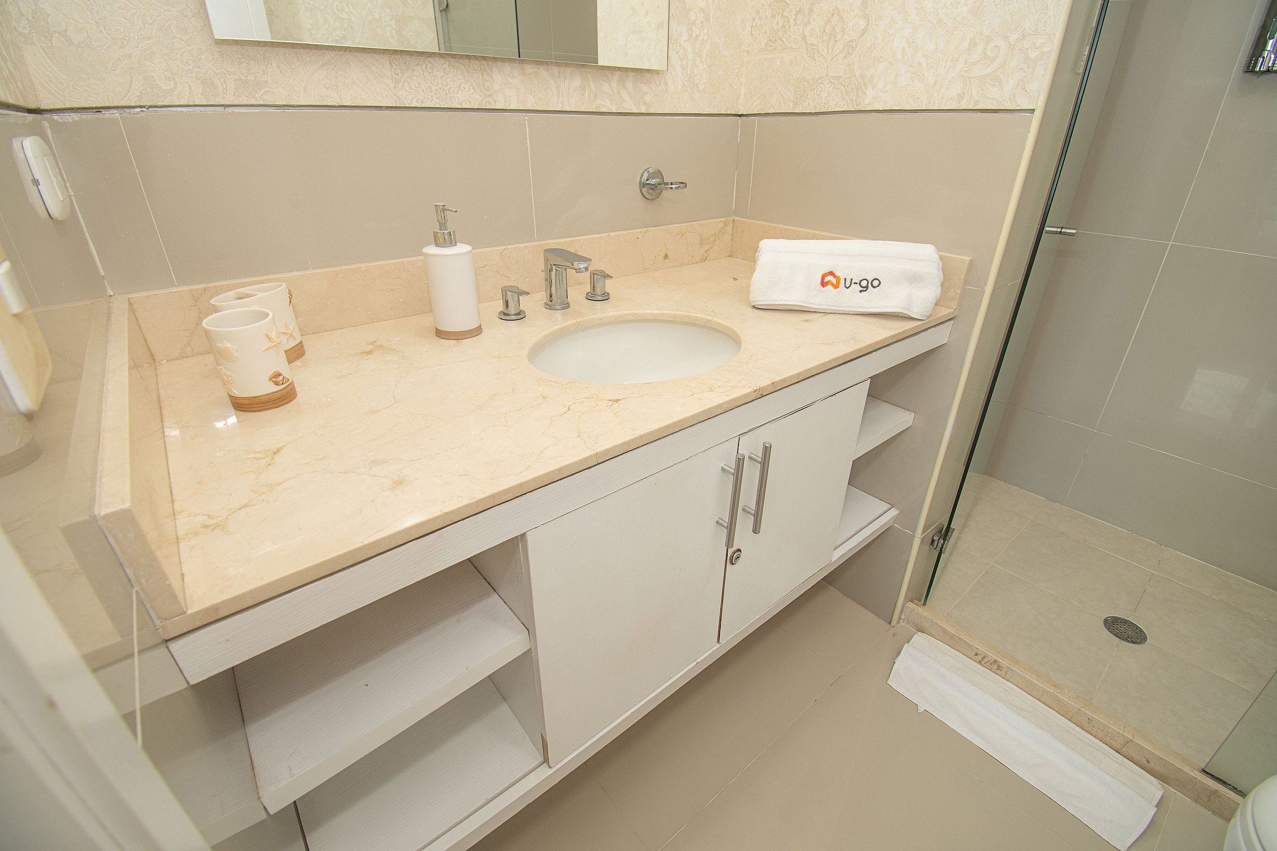 Ein Badezimmer mit Waschbecken, Spiegel und Dusche.