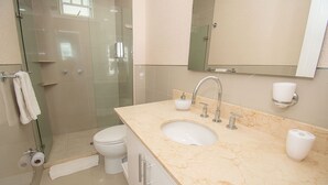 A modern bathroom with a glass shower enclosure, a white toilet, a marble sink with a faucet, and a mirror above the mirror cabinet. - U-GO Edificio Morros Ultra (Cartagena)
