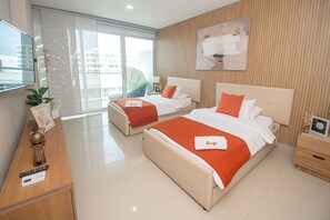 A hotel room with two beds, a TV, a desk, and a view of the city. - U-GO Edificio Morros Ultra (Cartagena)