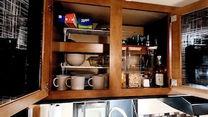 A kitchen with wooden cabinets, a glass-fronted spice rack, and a coffee maker. - RV/camper in terrific Via Madonna property (Englewood)