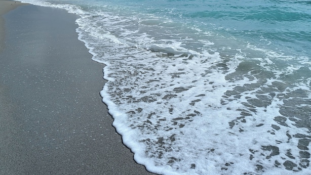 A beach with waves gently lapping onto the shore under a partly cloudy sky. - RV/camper in terrific Via Madonna property (Englewood)