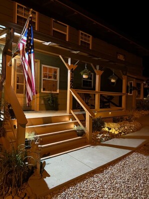 A two-story house with a porch, a flag, and a number '4142' on the front.