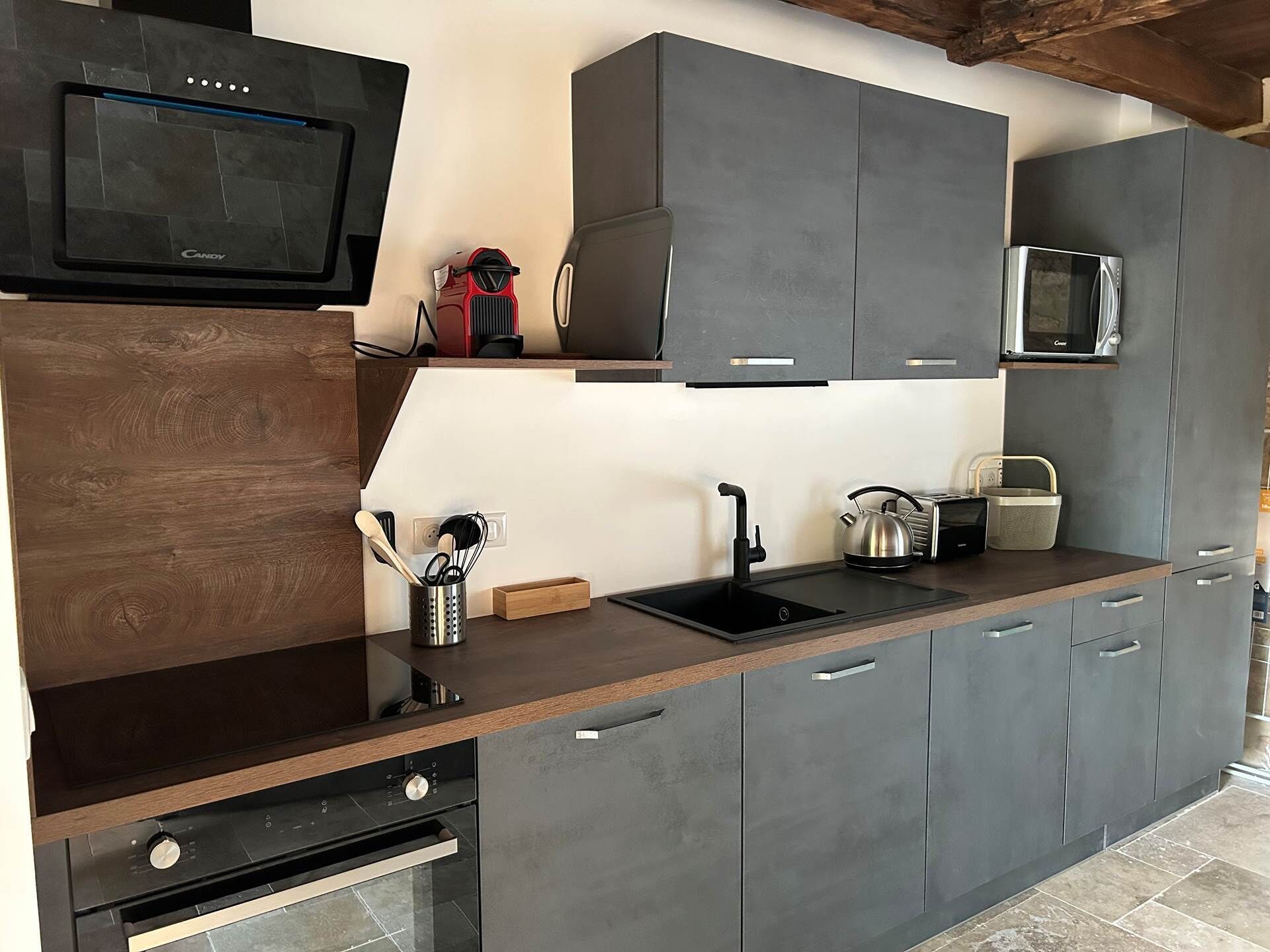 A modern kitchen with a built-in oven, a microwave, and a coffee machine.
