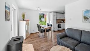 Un appartement moderne comprenant un coin repas, une cuisine et un salon.
