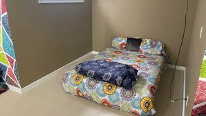 Ein Schlafzimmer mit einem Bett, einem Fenster und einem Wandbild.