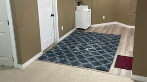 Ein Zimmer mit beigeem Teppich, einer weißen Tür, einem weißen Schrank und einem Spiegel an der Wand.